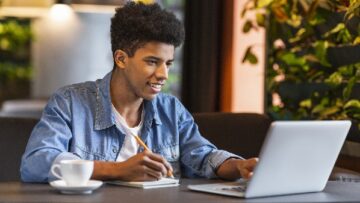 Young teen blogger making notes for new publication at cafe